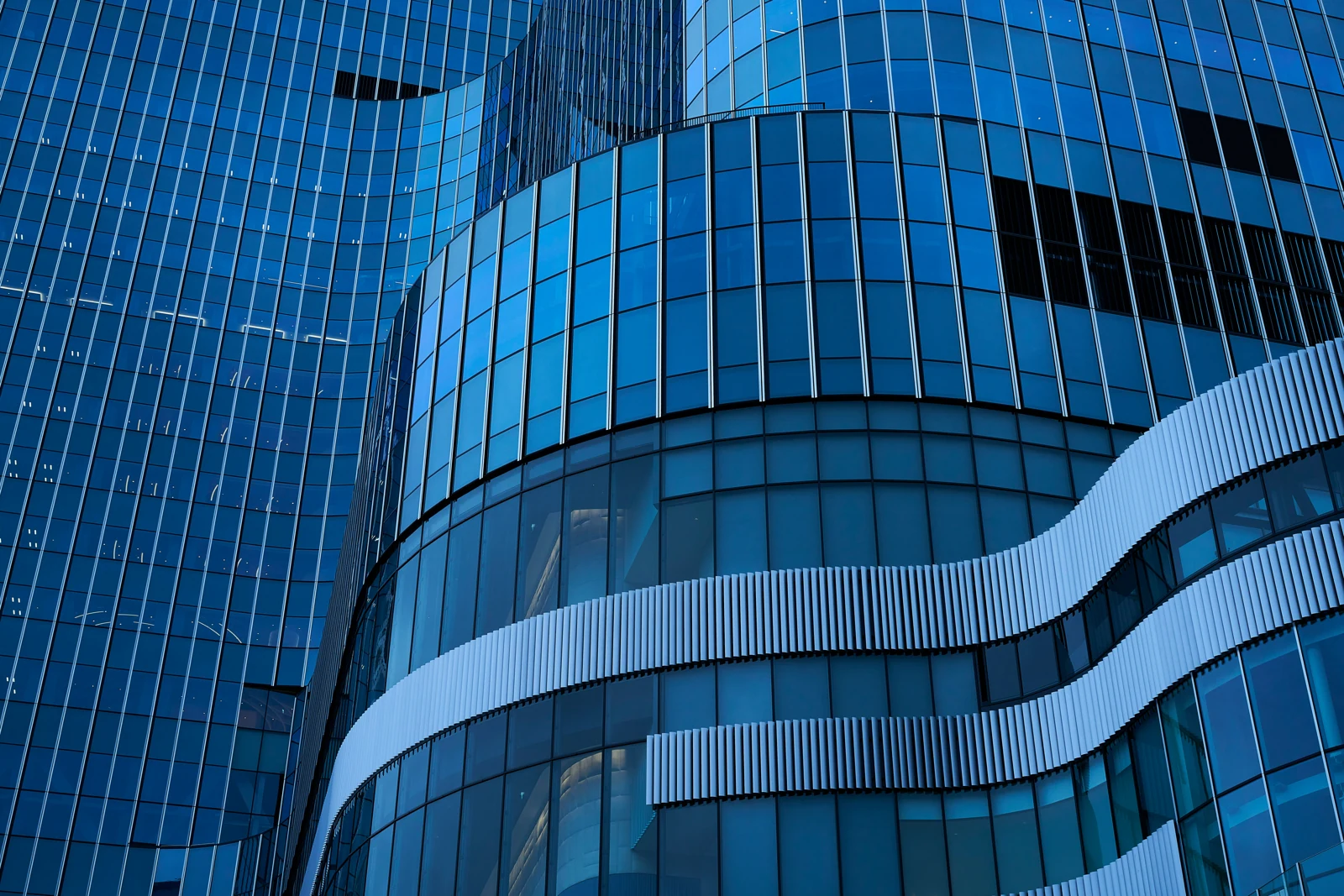 Blue glass architecture, with structural lines connecting across the façade